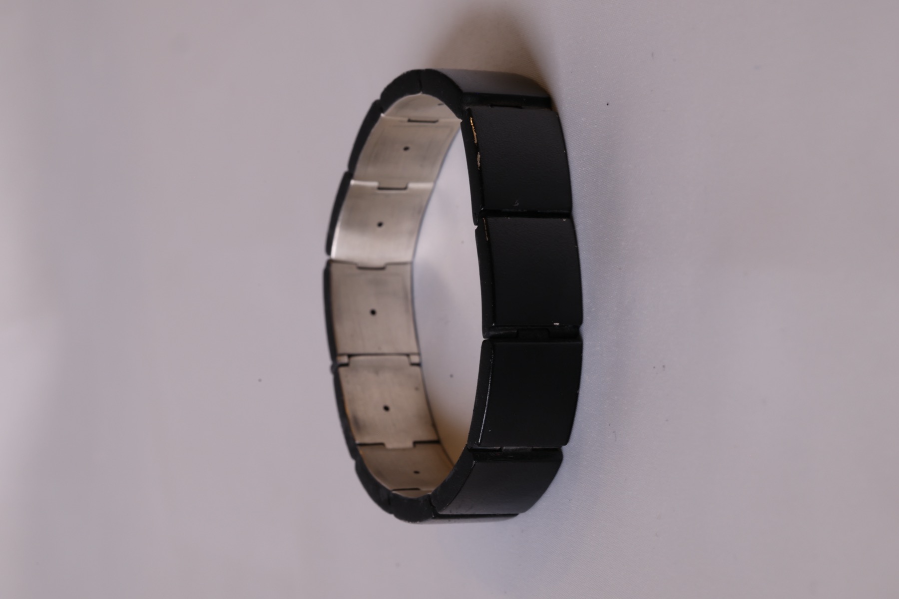 Vitul Onyx edition bracelet standing upright, showing the black links and steel inner face